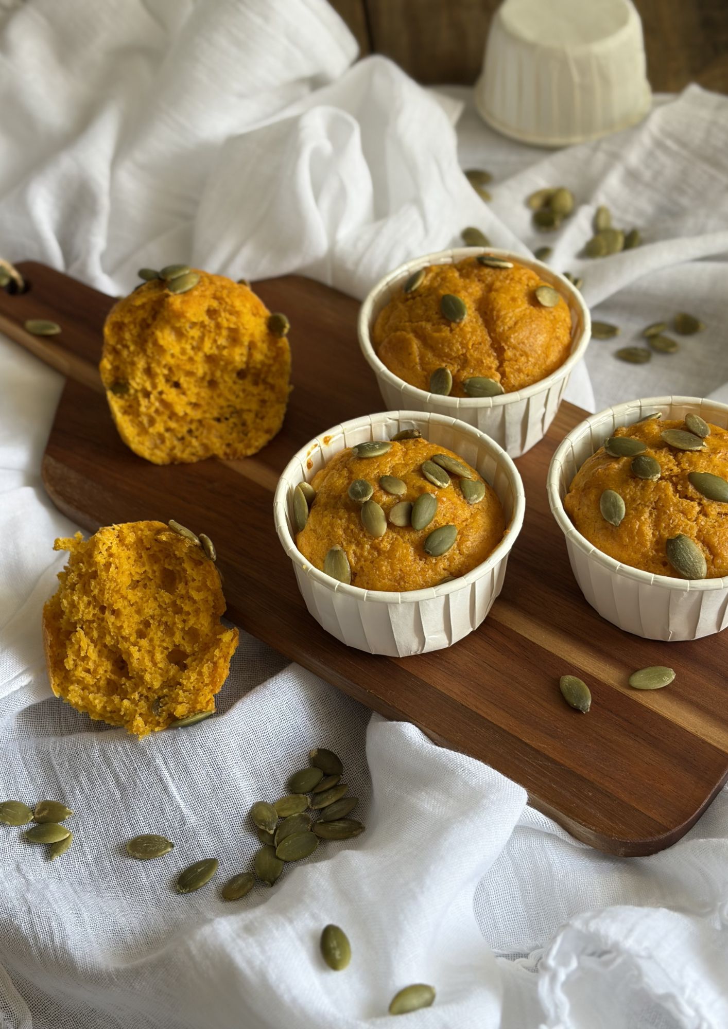 muffin salati con carote e parmigiano con semi di girasole su un tagliere di legno